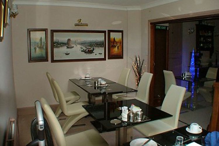 The breakfast room with a laid table and maritime pictures