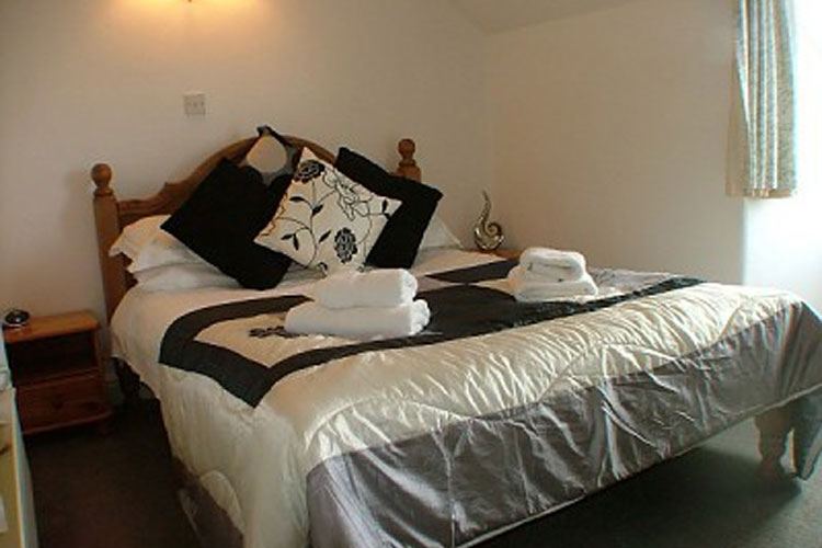 Double room interior, monochrome bedding